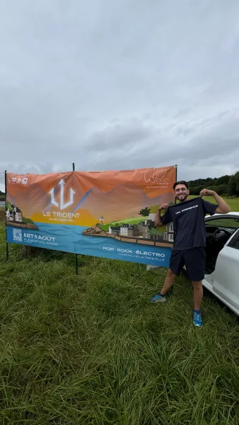 Un bénévole devant la banderole du Trident Festival